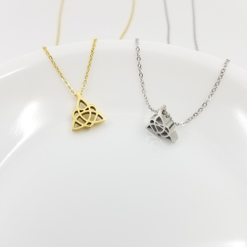 May include: Two delicate necklaces with Celtic knot pendants. One necklace has a gold pendant and the other has a silver pendant.
