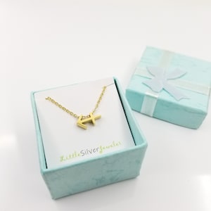 May include: Gold Sagittarius zodiac sign necklace in a light blue gift box with a white ribbon. The necklace is on a white card with the text "LittleSilverjeweler".