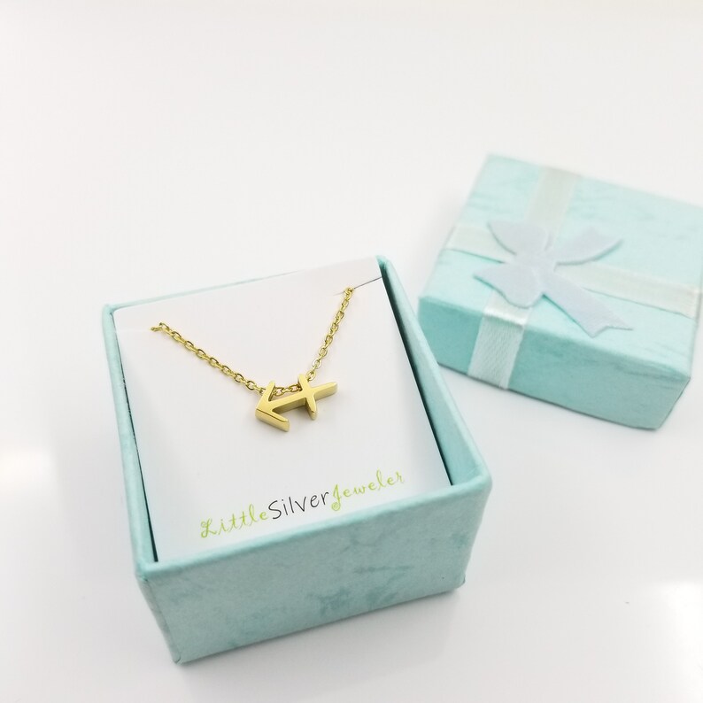 May include: Gold Sagittarius zodiac sign necklace in a light blue gift box with a white ribbon. The necklace is on a white card with the text "LittleSilverjeweler".