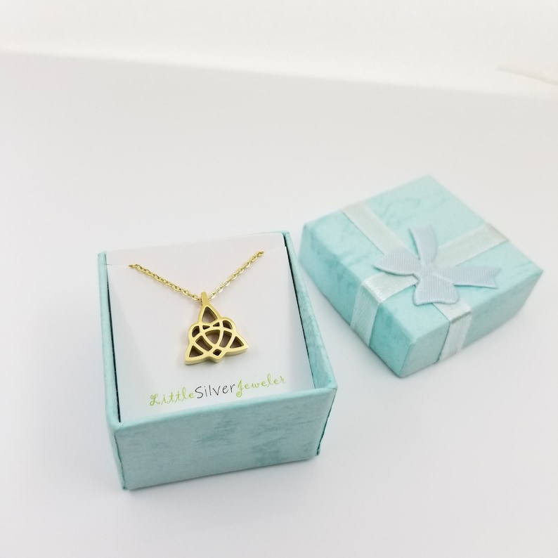 May include: Gold Celtic knot pendant necklace in a light blue gift box with a white ribbon and bow. The box has the text "LittleSilverJeweler" printed on the front.