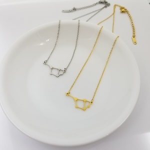 May include: Two delicate necklaces with a constellation design. One necklace is silver and the other is gold.