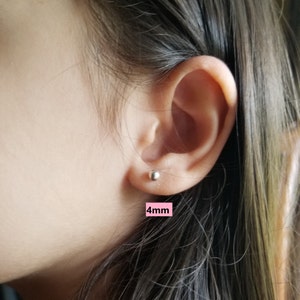 May include: Close-up of a person's ear with a small silver stud earring. The earring is 4mm in diameter.