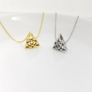 May include: Two delicate necklaces with a Celtic knot pendant. One necklace is gold and the other is silver.