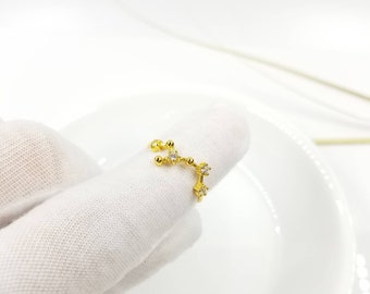 May include: Gold ring with a constellation design featuring small clear cubic zirconia stones.