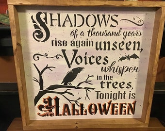 Op de afbeelding: Houten Halloween-bord met de tekst "Shadows of a thousand years rise again unseen, Voices whisper in the trees, Tonight is Halloween." Het bord toont een zwarte raaf, vleermuis en boomtak.