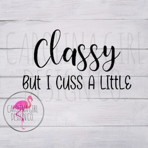 May include: A white wood background with black text that reads "Classy but I cuss a little". A pink flamingo logo is in the bottom left corner.