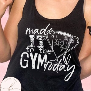 May include: Black tank top with white text that reads "made it to the gym today" with a trophy graphic and a heart.