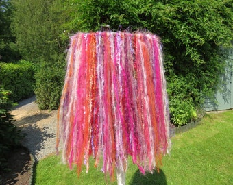 Boho ceiling pendant lampshade. Strands of mixed yarn in sunset colours.