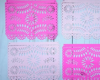 May include: Four rectangular paper cutouts in shades of pink. Each cutout features a detailed floral and leaf design with a scalloped edge. The cutouts are arranged on a light blue wooden surface.