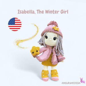 Puede incluir: Una muñeca de crochet que lleva un abrigo rosa, un vestido amarillo y un gorro gris con una estrella en la parte superior. La muñeca sostiene una estrella amarilla en su mano. La muñeca está de pie sobre un fondo blanco. El texto "Isabella, The Winter Girl" está escrito encima de la muñeca.