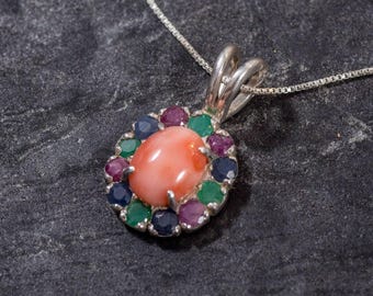 May include: A silver pendant necklace with a pink coral stone surrounded by a halo of green, blue, and red gemstones.