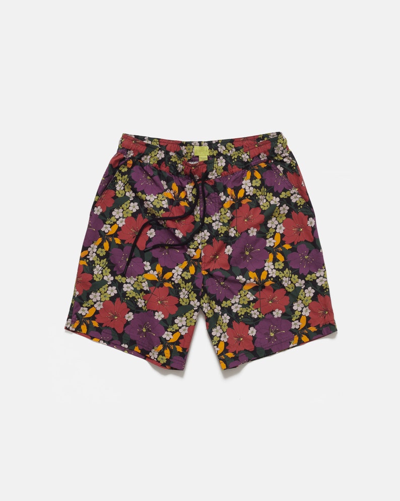 These Purple Tropical Floral shorts have a casual fit with two front pockets, one back pocket, and a drawcord for adjustability. They are made from a single layer of 100% Peached Cotton and woven using a Poplin weave.