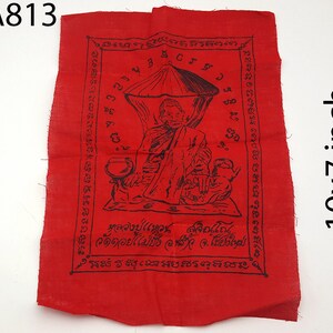 May include: A red cloth with a black illustration of a seated figure under an umbrella, with text in a foreign language. The cloth measures 10x7 inches.
