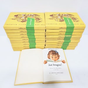 May include: A stack of 20 yellow and green paperback books with the title "The New Basic Readers: Just Imagine!" on the cover. The book cover features a cartoon illustration of a girl reading a book. The book is open to a page with the title "Just Imagine!" and the author's names.