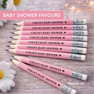 May include: Pink pencils with the text "CHLOE'S BABY SHOWER" and a heart symbol. The pencils have silver metal bands and white erasers. The image also includes the text "BABY SHOWER FAVOURS" and "Pack of 10+".