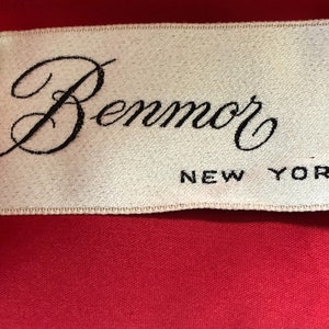 Puede incluir: Una etiqueta blanca con texto negro que dice "Benmor NEW YORK".