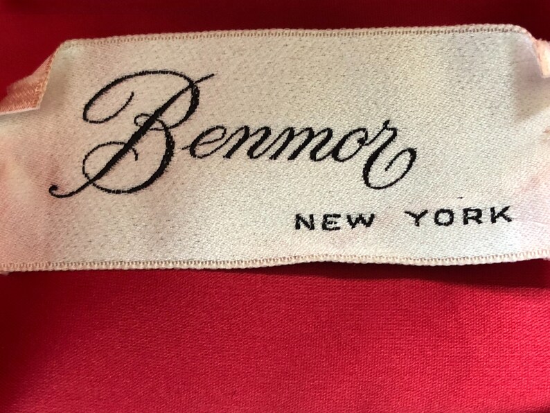 Puede incluir: Una etiqueta blanca con texto negro que dice "Benmor NEW YORK".