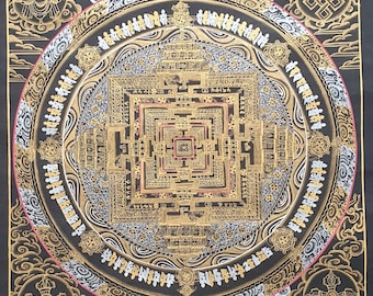 May include: A traditional Tibetan mandala with intricate details in gold and silver on a black background. The mandala features a central square with concentric circles and a variety of symbols and patterns.