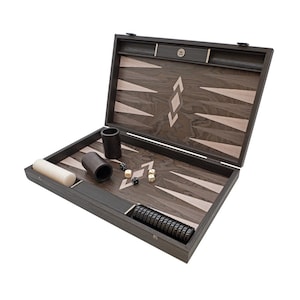May include: Open backgammon set with a dark wood finish. The game board features a contrasting light wood pattern with inlaid points. Includes dice, doubling cube, and playing pieces. A classic board game for two players.