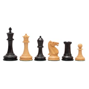 May include: A selection of six chess pieces, including a black king, a white queen, a black bishop, a tan knight, a black rook, and a tan pawn. The pieces are displayed in a line against a white backdrop.