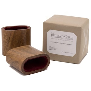 Puede incluir: Vasos de dados de madera de forma ovalada, con exterior de madera oscura e interior de terciopelo rojo. La imagen también muestra una caja con el texto "THE REGENCY CHESS COMPANY" y "Solid Wooden Deluxe Dice Cups for Backgammon".
