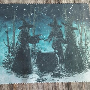May include: A dark, textured print depicts three witches in long dresses and pointed hats gathered around a bubbling cauldron in a forest. The background is a teal and blue night scene with trees and stars.