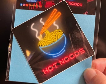 May include: A sticker with a neon sign design of a bowl of ramen noodles with chopsticks. The sticker says "HOT NOODS" in red neon letters.