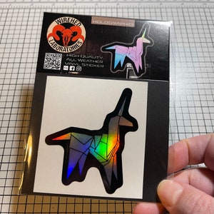 May include: A holographic sticker of a origami unicorn in a rainbow color scheme. The sticker is on a white background with a black border. The sticker is from Wired Laboratories.