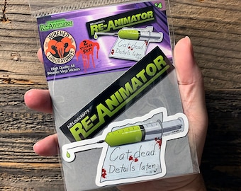 Puede incluir: Un conjunto de pegatinas que presenta una jeringa verde con una gota de sangre y una nota que dice "Cat dead. Details later." El conjunto de pegatinas está empaquetado en una bolsa de plástico transparente con un fondo blanco y el texto "Re-Animator" en negro y verde.
