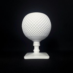 Może przedstawiać: Biały wazon z mlecznego szkła z okrągłą, fakturowaną misą i kwadratową podstawą.