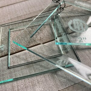 May include: A set of three clear acrylic quilting rulers with etched measurements in inches. The rulers are labeled "Quilting Squares" and "LaserHawk".