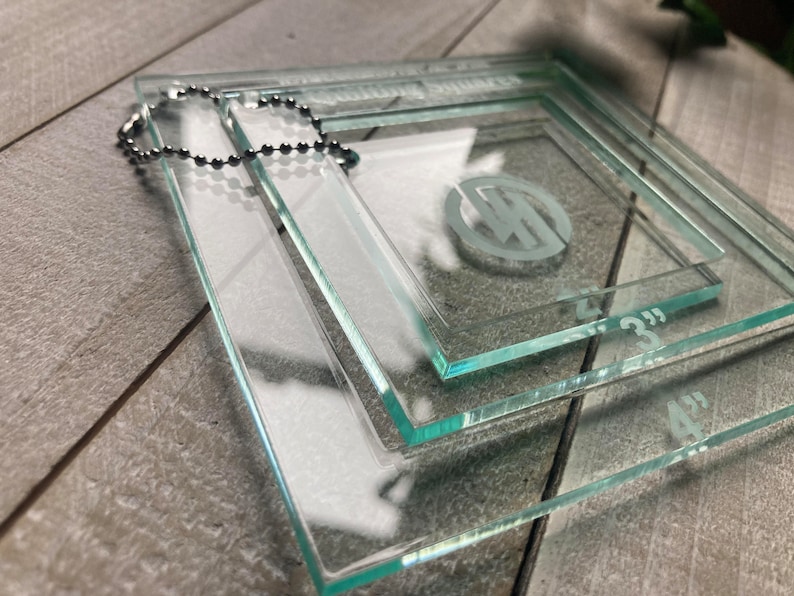 May include: Three clear glass squares with rounded edges, stacked on top of each other. The squares are labeled with the measurements 4", 3", and 2".