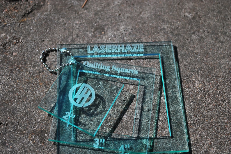 May include: Set of four clear blue acrylic quilting squares with measurements of 2", 3", and 4". The squares are labeled "LaserHaze Quilting Squares".