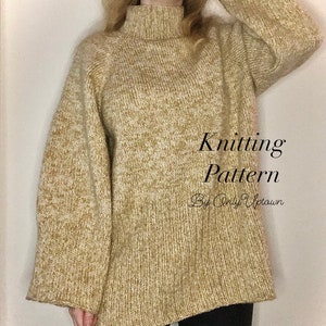 Puede incluir: Un suéter tejido beige y marrón claro con cuello alto y mangas largas. El texto "Knitting Pattern By Only Uptown" es visible en la parte delantera del suéter. El suéter se usa con leggings negros.