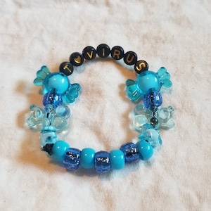 May include: A blue and black beaded bracelet with the word "I ♥ VIRUS" spelled out in black beads.