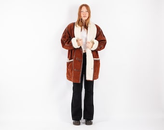 May include: A brown suede and faux fur coat with a brown button closure and a white faux fur lining.