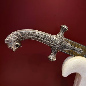 インドの手作りのラージプート インド ペルシャ シャムシール。純銀製のハンドグリップと鞘に、手彫りの彫刻が施されたライオンの頭のハンドグリップ付き。