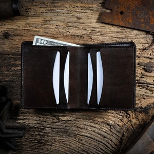 May include: A brown leather wallet with a &pound;10 note sticking out of it. The wallet is open and has several card slots.