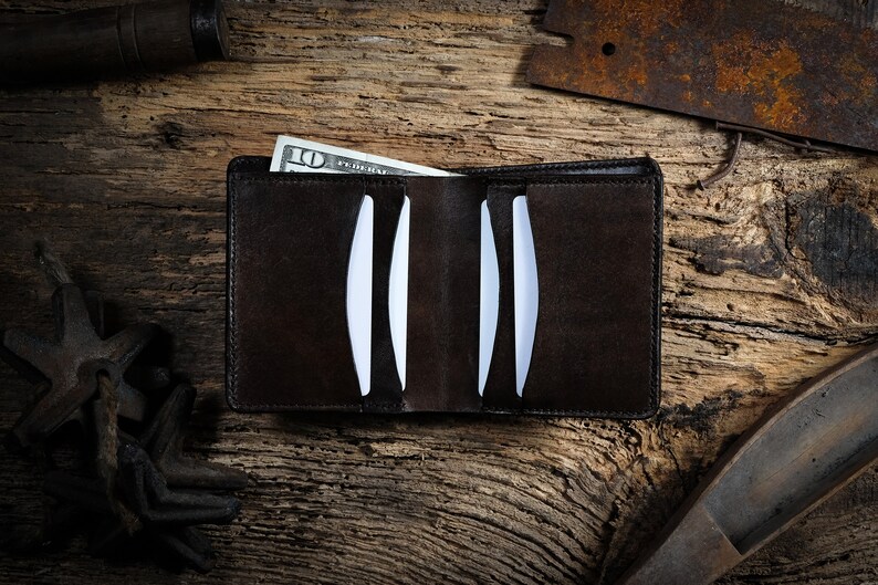 May include: A brown leather wallet with a &pound;10 note sticking out of it. The wallet is open and has several card slots.