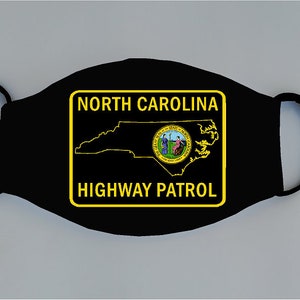 May include: Black face mask with a yellow border and the text "NORTH CAROLINA HIGHWAY PATROL" inside. The state of North Carolina is outlined in yellow inside the border, and the state seal is in the center.