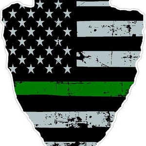 May include: A black and white American flag with a green stripe across the middle. The flag is distressed and has a jagged edge.