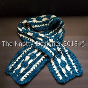 May include: A teal and white crocheted scarf with a repeating pattern of white circles and scallops. The scarf is folded in half and lying on a dark gray surface.