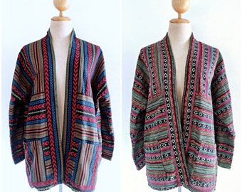 May include: Two long-sleeved jackets with a colorful geometric pattern. The jackets are open in the front and have a shawl collar. The jackets are made of a woven fabric and have a relaxed fit.