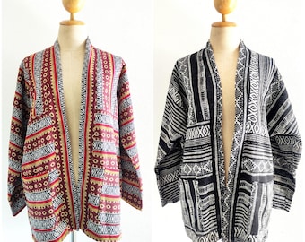 May include: Two open-front jackets with geometric patterns. One jacket is black and white, the other is red, gold, and black.