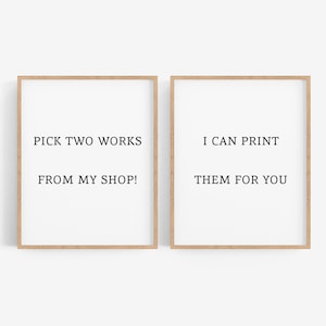May include: Two framed prints with light wood frames. The left print reads "PICK TWO WORKS FROM MY SHOP!". The right print reads "I CAN PRINT THEM FOR YOU". The prints are on a white background.