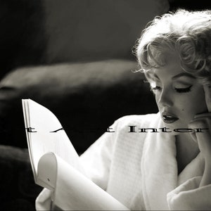 Peut inclure: Une photographie en noir et blanc montrant une personne aux cheveux blonds bouclés portant un peignoir blanc, lisant un livre ouvert. Le texte Violet Art Interior est superposé au centre de l'image dans une fine police noire sans empattement.