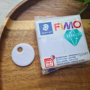 May include: A package of white FIMO Effect modeling clay with a blue and white logo. The package includes instructions for baking the clay at 110 degrees Celsius or 230 degrees Fahrenheit. The clay is 57 grams or 2 ounces.