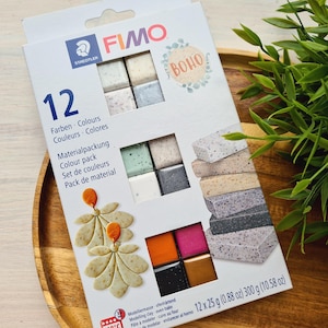 May include: A FIMO colour pack with 12 colours, including shades of grey, white, green, and pink. The box features the word "BOHO" and includes 12 x 25 g (0.88 oz) of modelling clay.
