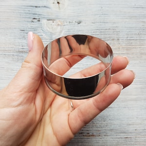 May include: A silver metal ring mold for baking. The mold is round and has a smooth, shiny surface.