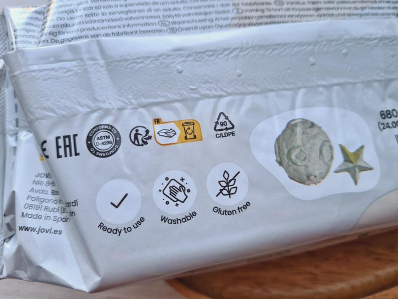 Pode incluir: Uma embalagem branca com uma marca de verifica&ccedil;&atilde;o, as palavras "Pronto a usar", "Lav&aacute;vel" e "Sem gl&uacute;ten", e um s&iacute;mbolo de reciclagem. A embalagem tamb&eacute;m tem o texto "Conforme ASTM D-4236", "Eac" e "FR".